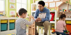 Hochbegabung: Erzieher beobachtet Verhaltensauffälligkeiten bei spielendem Kind im Kindergarten.