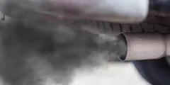 Treibhausgasminderungsquote: Nahaufnahme eines Auto-Auspuffs, aus dem Abgase austreten.